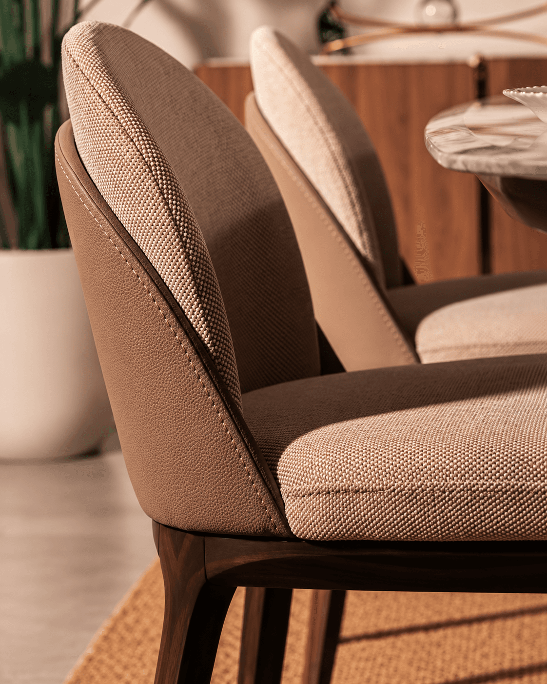 ELORA premium upholstered dining chair showing its rounded padded back, textured brown upholstery and dark wooden frame in close-up.